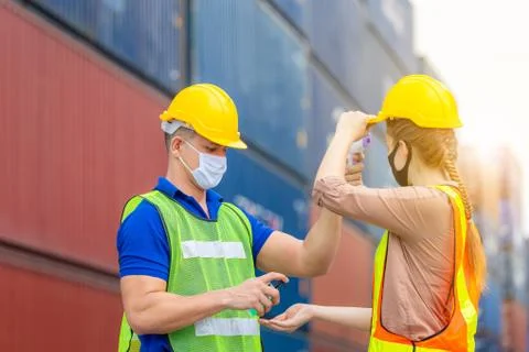Factory worker man checking fever by digital thermometer for scan and protect Foto stock