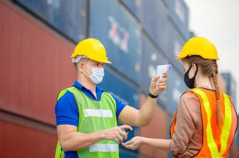 Factory worker man checking fever by digital thermometer for scan and protect Fotos Stock