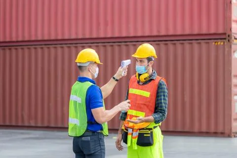 Factory worker man checking fever by digital thermometer for scan and protect Stockfoto's