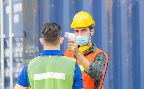Factory worker man checking fever by digital thermometer for scan and protect Foto stock