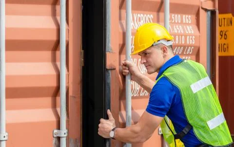 Factory worker man in hardhat and safety vest checking containers box from ca Stockfoto's