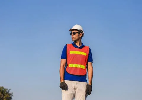 Factory worker man standing on container box and looking to the sky Stockfoto's