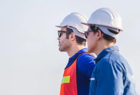 Factory worker man team in hard hat and looking at sky with joy 写真素材