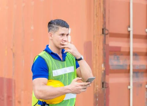 Factory worker man uses mobile phone, engineer using mobile smartphone in ind Фото