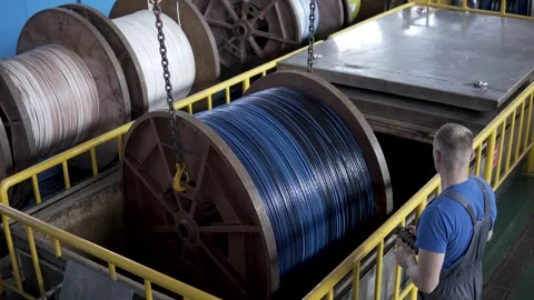 Factory worker monitors production process of wire spools in industrial facility Stock Footage 306300073