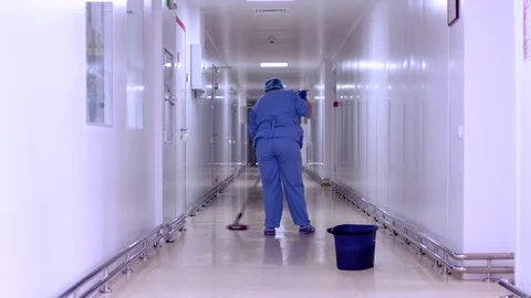 Factory worker mopping floor in hospital corridor. Cleaner cleaning corridor Stock Footage 77109314
