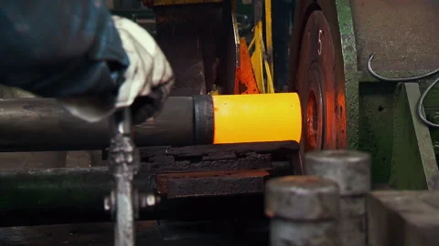 Factory Worker Observing Orange Hot Copper Slab Moving into Shaping Machine Stock Footage 243115025