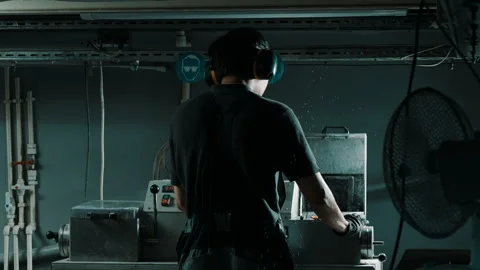 Factory worker operating industrial machine with ear protection Stock Footage 337927589