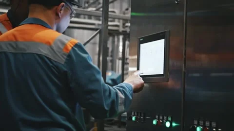 Factory worker operating industrial touchscreen control panel Stock Footage 337411147