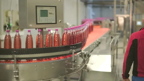 Factory worker operating touch screen control panel on automated bottling line Stock Footage 328608064