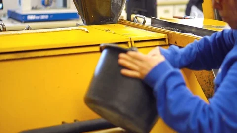 The factory worker pours the granulate into the machine for processing Stock Footage 93448837