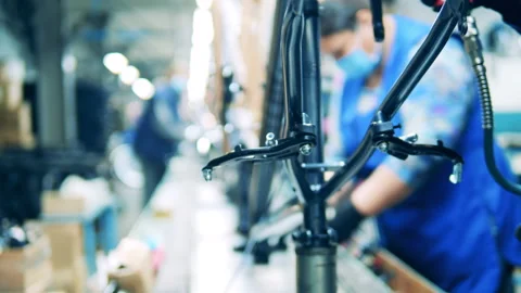 Factory worker is processing a bicycle body frame Stock Footage