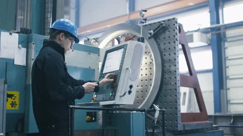 Factory worker is programming a CNC milling machine with a tablet computer Stock Footage
