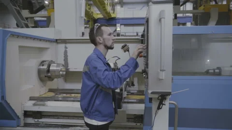Factory worker is programming a CNC milling machine 库存影片 103354702