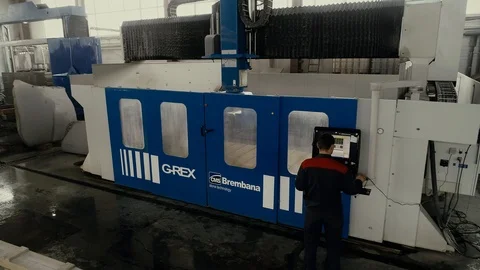 Factory worker is programming a CNC milling machine with a tablet computer. Video stock 106451845
