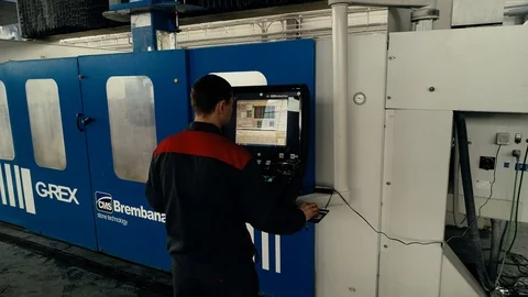 Factory worker is programming a CNC milling machine with a tablet computer. Video stock 106451874
