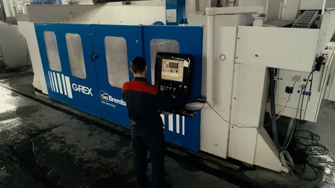 Factory worker is programming a CNC milling machine with a tablet computer. Video stock 106451977