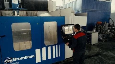 Factory worker is programming a CNC milling machine with a tablet computer. Video stock 106452022