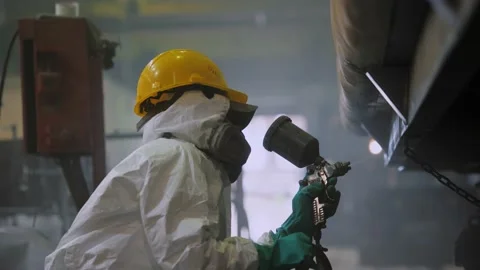 Factory worker in protective suit paints surface of train wagon with spray gun Stock-Footage 137698154