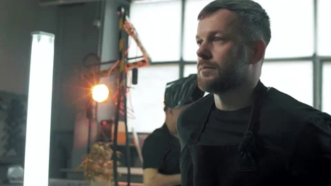 Factory worker puts on a protective coat and goes to his machine. Portrait Stock Footage 179686903