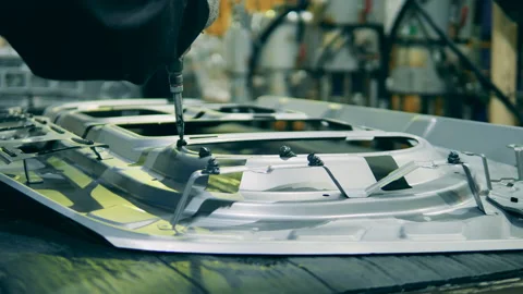 Factory worker is putting glue onto a frame of a car door. Automobile factory Vídeo Stock 141120411
