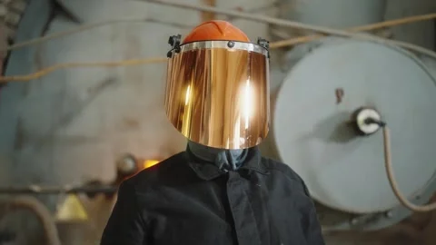 Factory worker with a reflective fireproof face shield and safety helmet Video stock 274490416