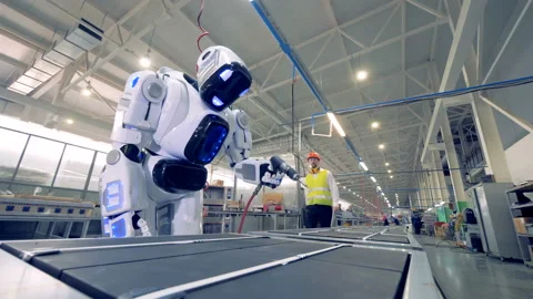 Factory worker is regulating robot's settings by remote control during working Stock Footage 89613102