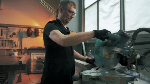 Factory worker saws a metal part with a circular saw Stock Footage 179686940
