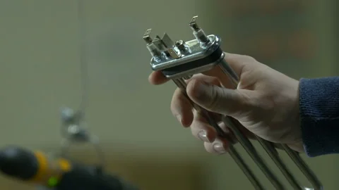Factory worker shows heating element of a washing machine Stock Footage 90022545