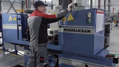 Factory worker switches the lever and closes machine's doors Video stock 129639778
