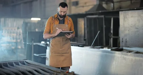 Factory worker with tablet and phone at the manufacturing Stock Footage 147290864