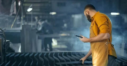 Factory worker with tablet and phone at the manufacturing Stock Footage 147292650