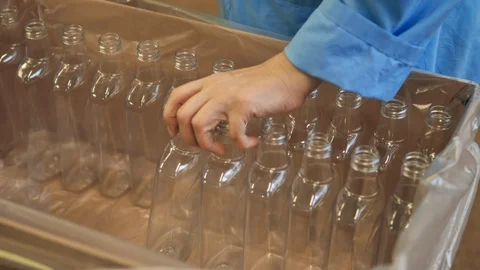 A factory worker takes plastic bottles out of the box. Plastic production. Stock Footage 128449975