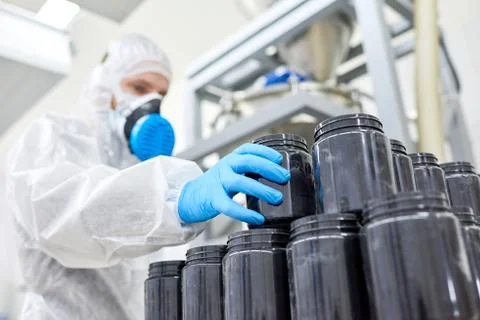 Factory worker taking plastic container from stack Stock Photos