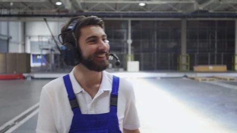 Factory worker talking through headphones and checking product quantities in Video stock 108458327