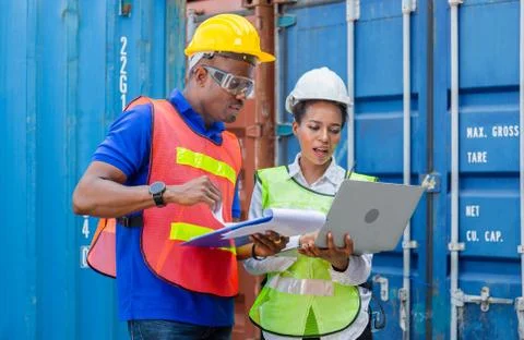 Factory worker team in hardhat holding clipboard checklist and laptop Фото
