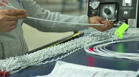 A factory worker twists cables in a machine Video stock 49087470