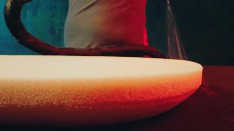Factory worker in an upholstery workshop spraying adhesive onto a foam cushion Stock Footage 337589811