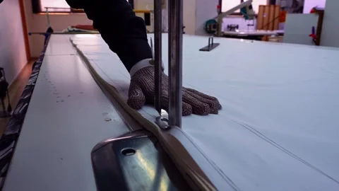 Factory Worker Using Chainmail Safety Glove to Cut Fabric with Automatic Cutt Stock Footage 335065882