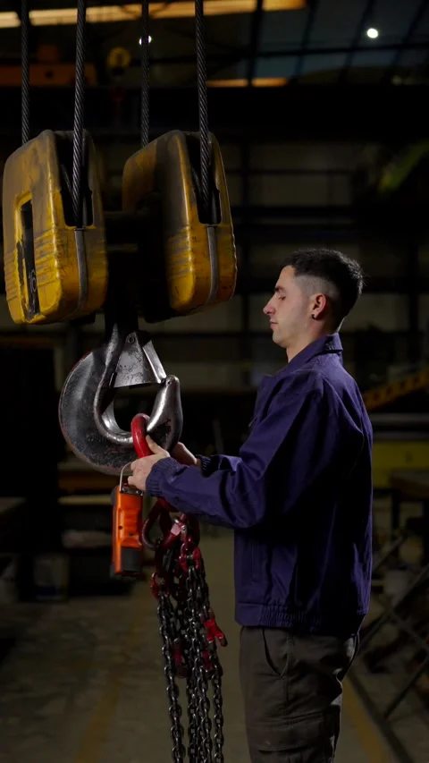 Factory worker using a crane to lift chains 스톡 동영상 266184571