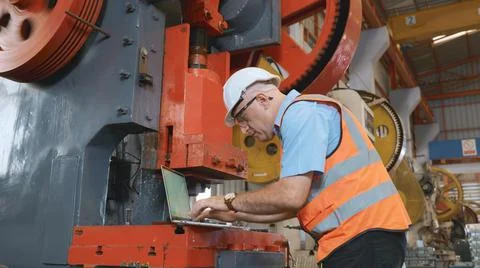 Factory worker using a laptop with an engineering software Stockfoto's