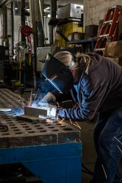Factory worker using Oxyacetylene gas to weld two piece of metal in a sheet Stock Photos