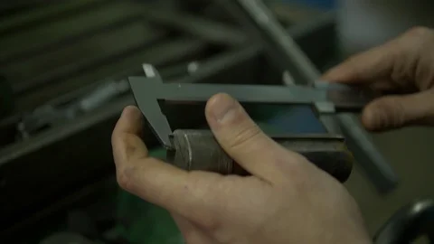 A factory worker is using a slide gauge to measure some detail. Vídeo Stock 118188610