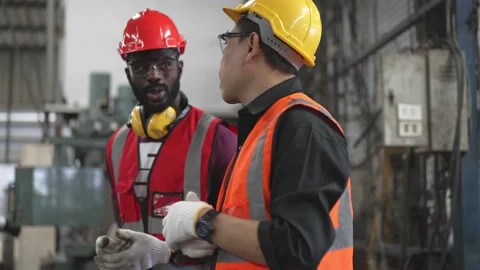 Factory worker walking and explaining work to colleague Stock Footage 194415475
