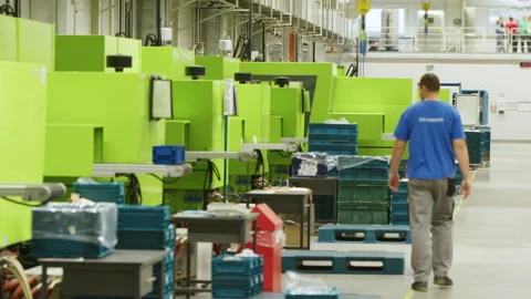 Factory Worker Walking by Lined up Modern Injection Moulding Machines Stock Footage 266690739