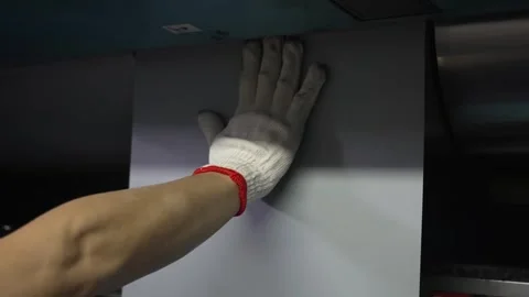 Factory worker wearing white cotton gloves manually threading paper web through Stock Footage 337889890