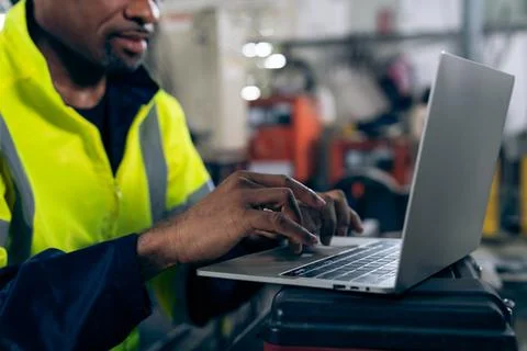 Factory worker working with laptop computer to do adept procedure checklist Stock Photos