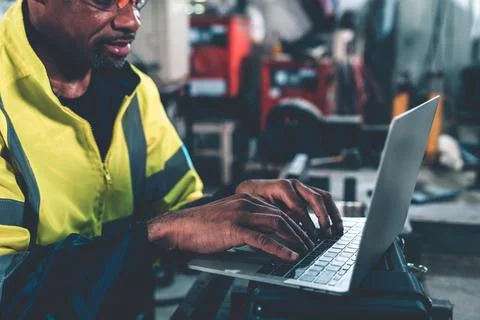 Factory worker working with laptop computer to do adept procedure checklist Stock Photos