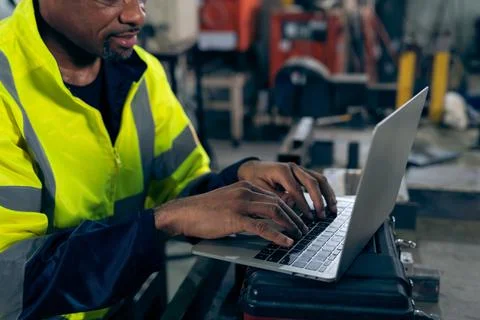 Factory worker working with laptop computer to do adept procedure checklist Stock Photos