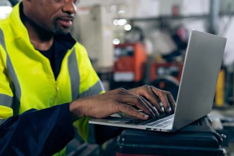 Factory worker working with laptop computer to do adept procedure checklist Stock Photos